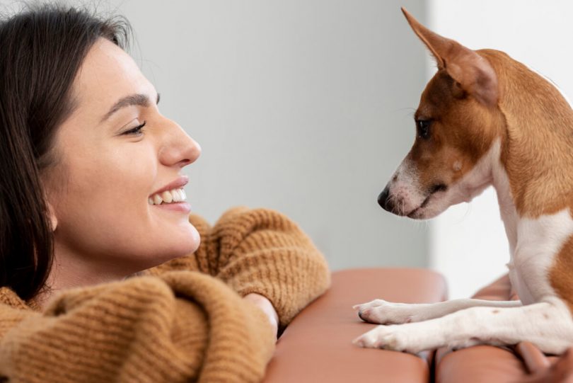 Uśmiechnięta kobieta i pies - Jaką rasę psa wybrać i na co zwrócić uwagę